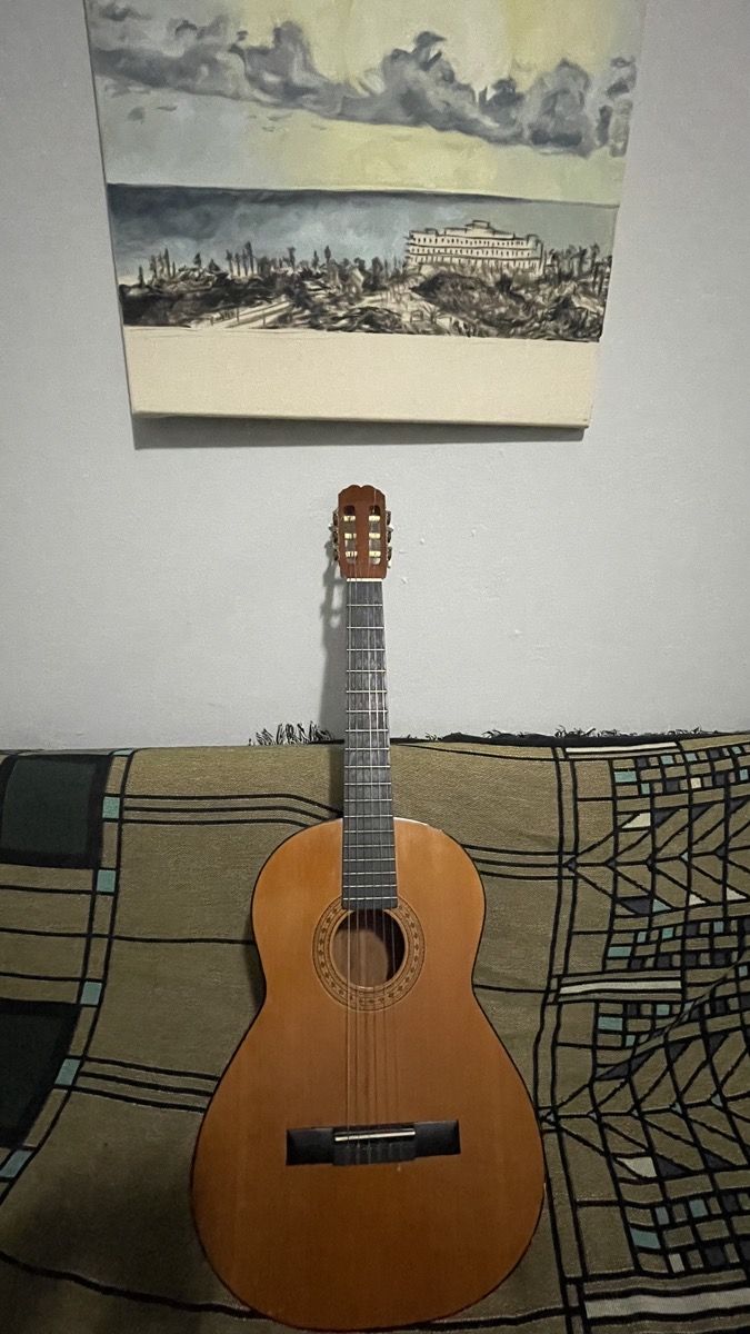 Classical guitar leaning against a wall